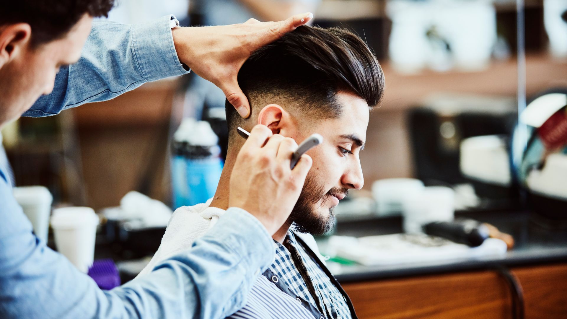 Barber creating a precise modern haircut with professional tools